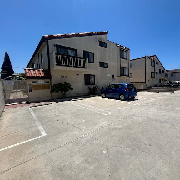 a parking lot with a building and a car.