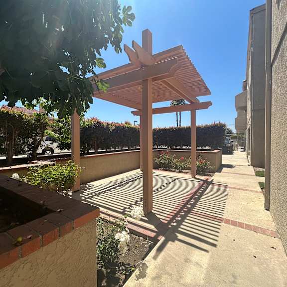 a wooden bench is suspended from a metal structure.