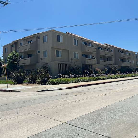 a long building with balconies is on the side of a street.