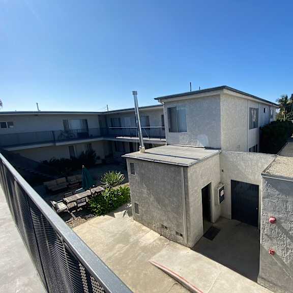 a concrete building with a balcony and a small entrance.