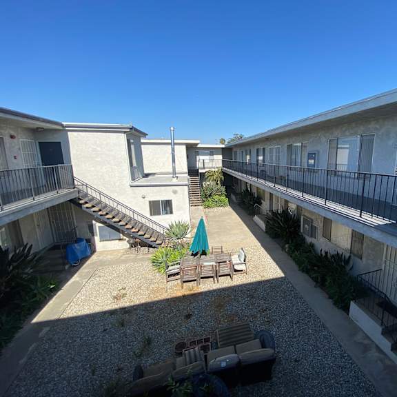 a courtyard with a table and chairs surrounded by buildings.
