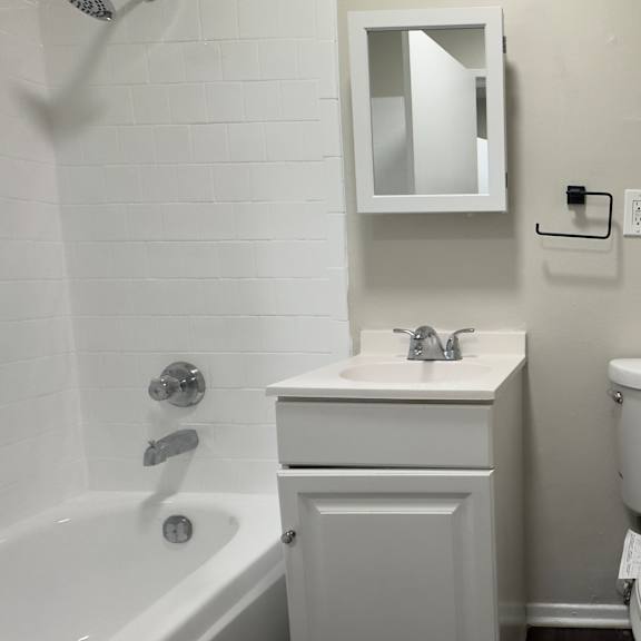 a white toilet sits next to a white sink in a small bathroom.