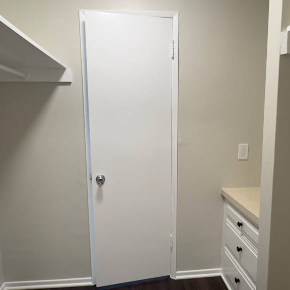 a white door is in a room with white walls.
