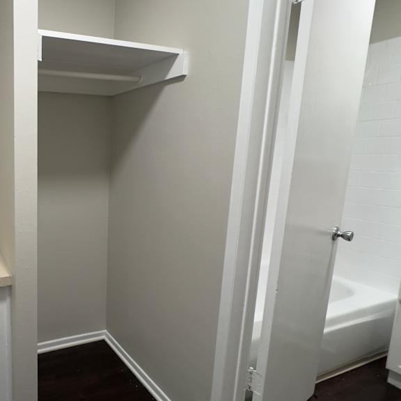 a white bathroom with a white towel rack and a white door.