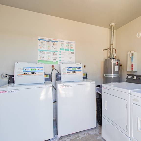 a laundry room with a washer and dryer and a sign on the wall.