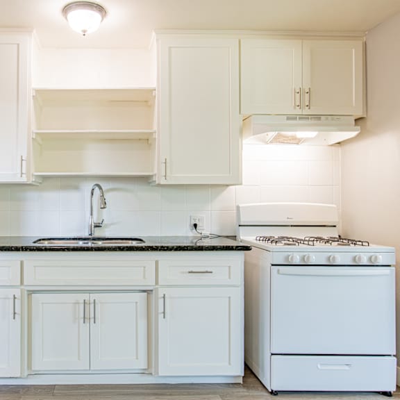 a kitchen with white cabinets and appliances.