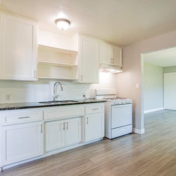 a kitchen with white cabinets and a black countertop.