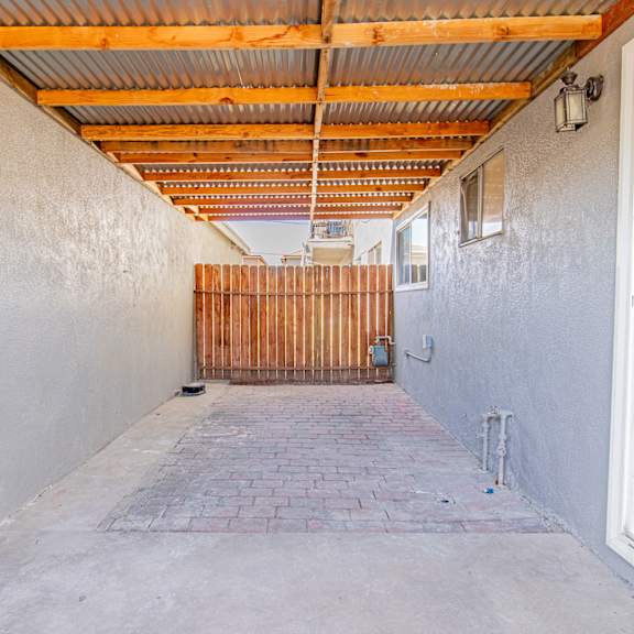 a long, narrow hallway with a wooden gate at the end.