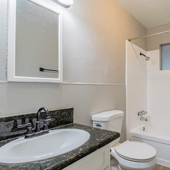 a bathroom with a toilet, sink, and bathtub.
