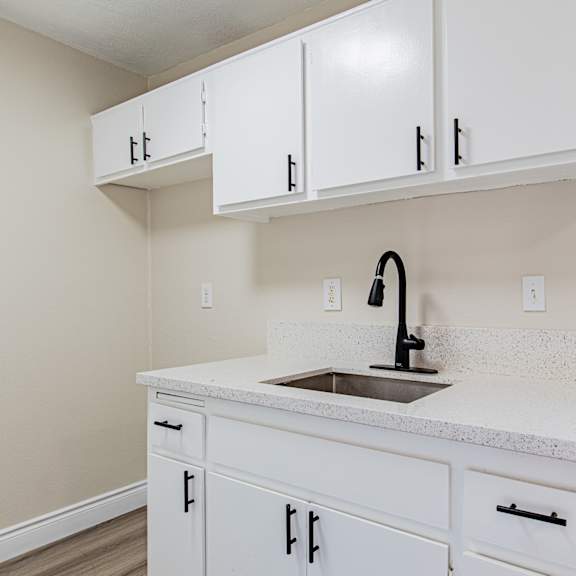 a kitchen with white cabinets and a granite countertop.