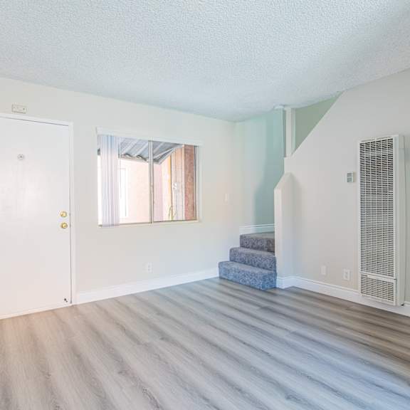 a room with a staircase and a window with curtains.