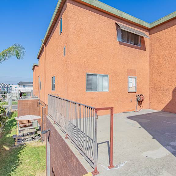 a red building with a green roof and a balcony.