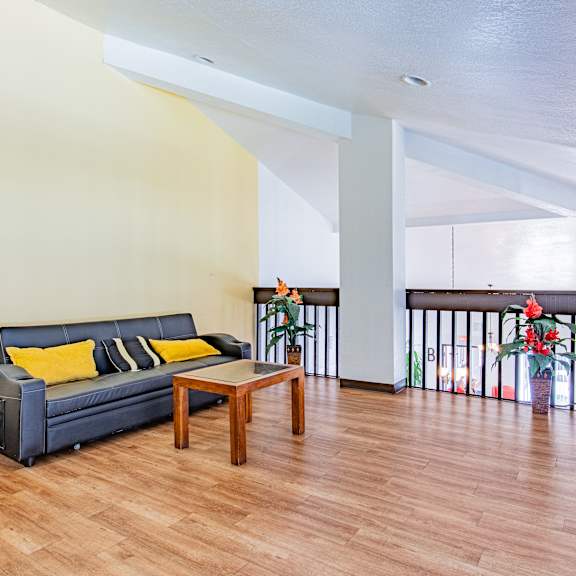 a living room with a black couch and a wooden coffee table.