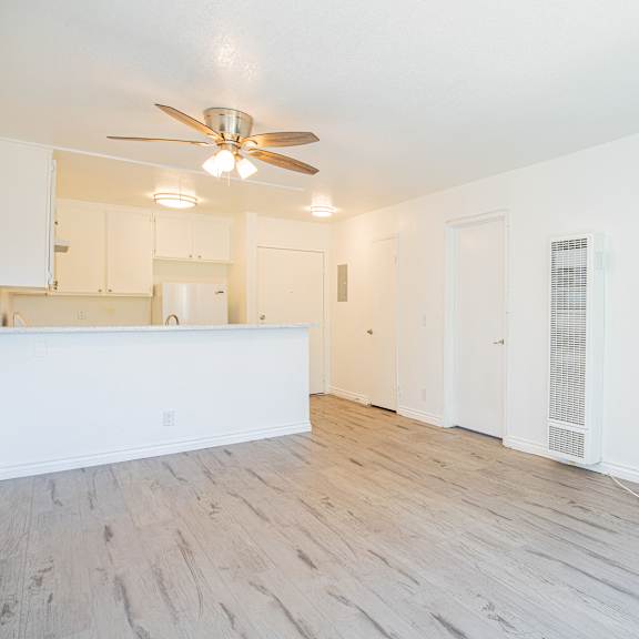 a room with a ceiling fan and wooden flooring.