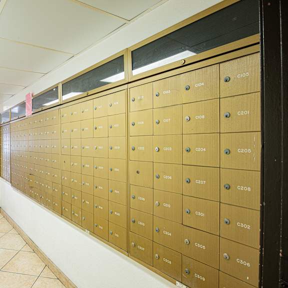 a long hallway with a wall of mailboxes on the right.