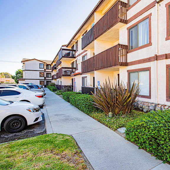 a white car is parked on a sidewalk in front of a building.