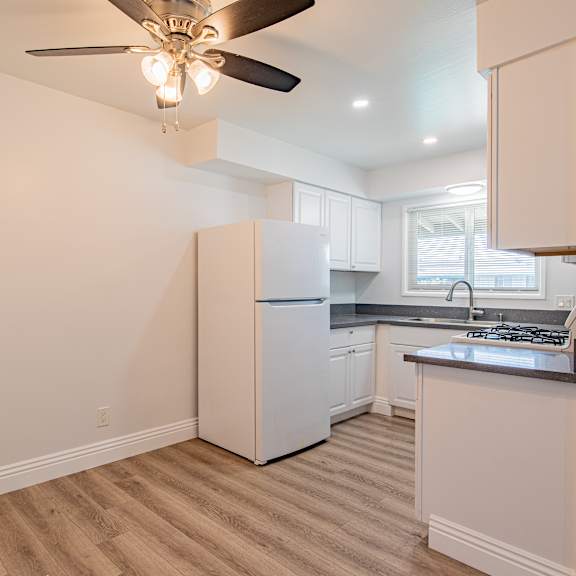 a kitchen with a refrigerator, stove, and sink.