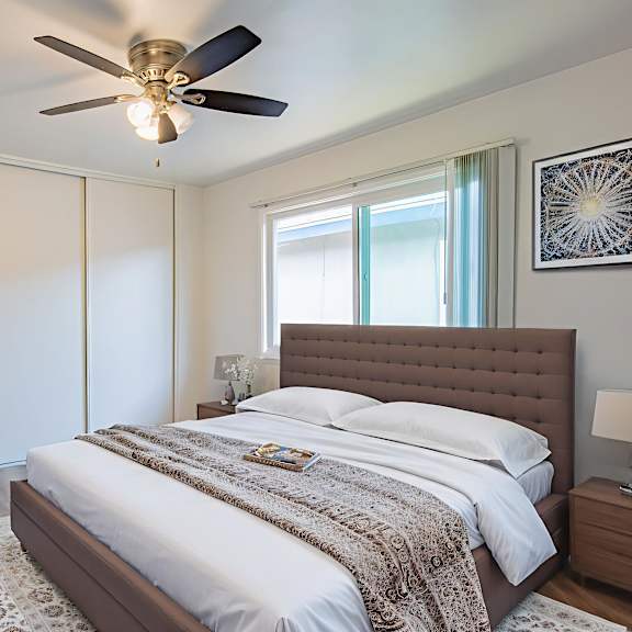 a bedroom with a large bed and a ceiling fan.