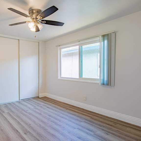a room with a ceiling fan and a window.