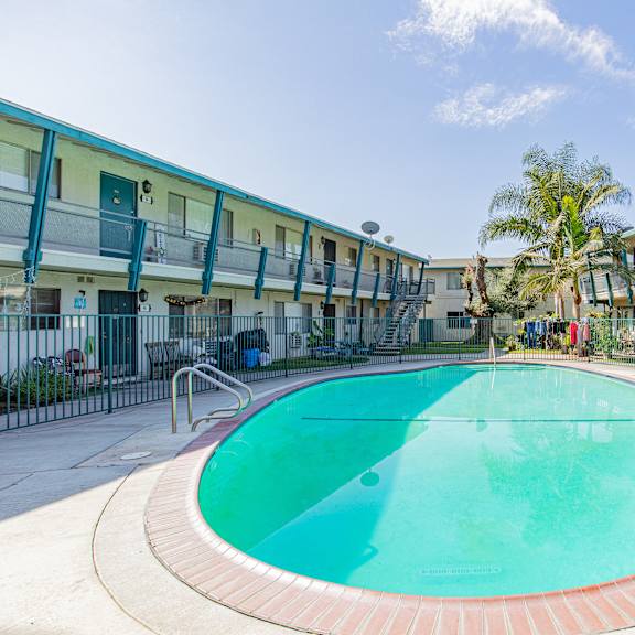 a swimming pool in a courtyard surrounded by apartment buildings.