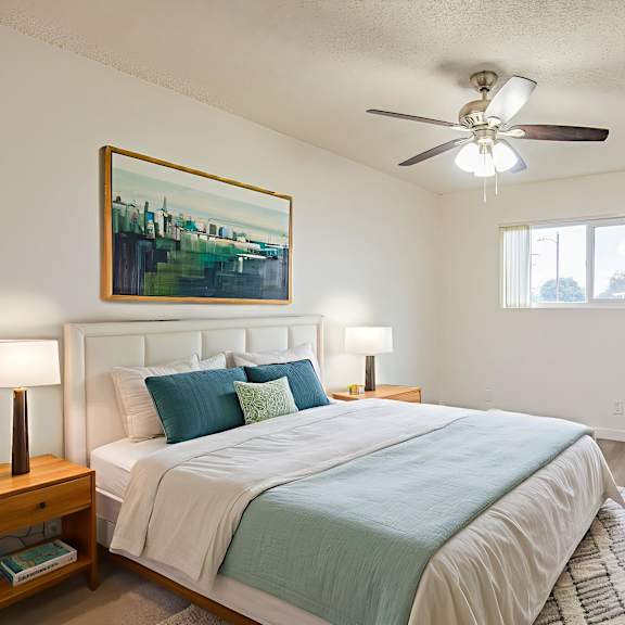 a bedroom with a bed, nightstand, and a painting on the wall.