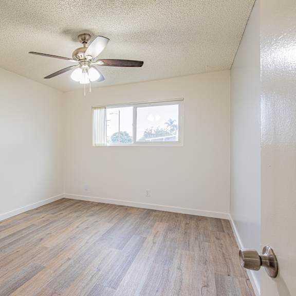 a room with a ceiling fan and a window.