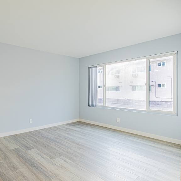 a room with a window and wooden flooring.