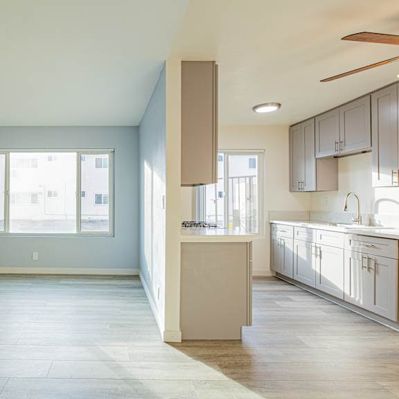 a spacious kitchen and living room with a large window.