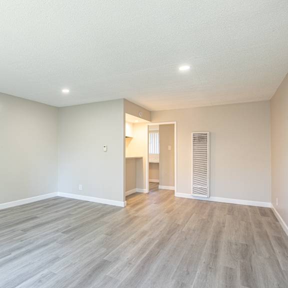 a room with a wooden floor and white walls.