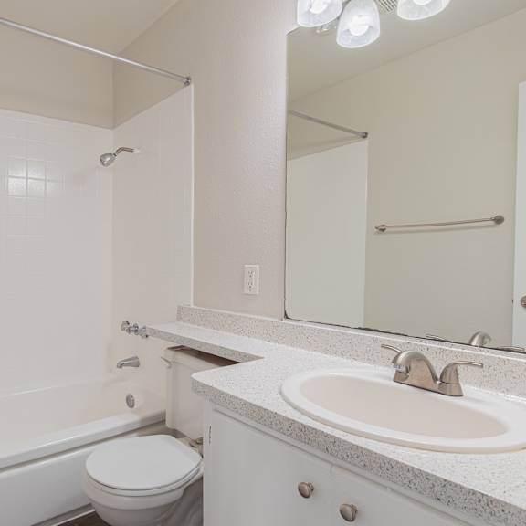 a white bathroom with a toilet, sink, and bathtub.