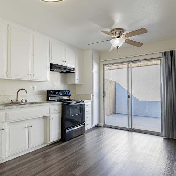 a kitchen with white cabinets and a black stove top oven.
