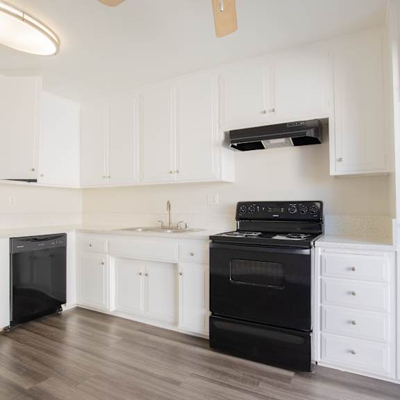 a kitchen with black appliances and white cabinets.