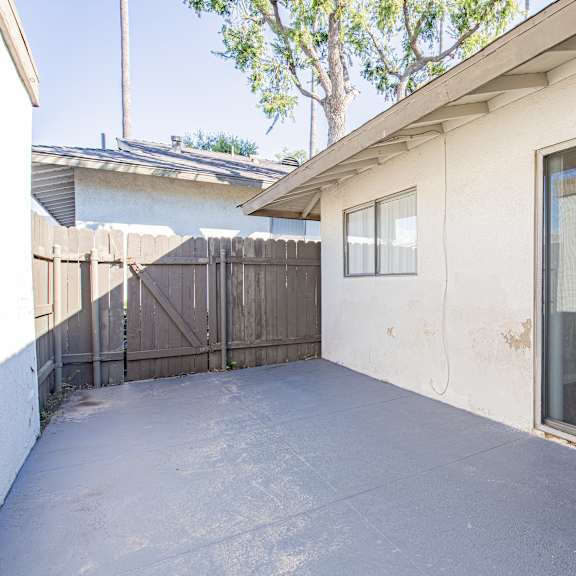 a patio area of a house with a sliding glass door.