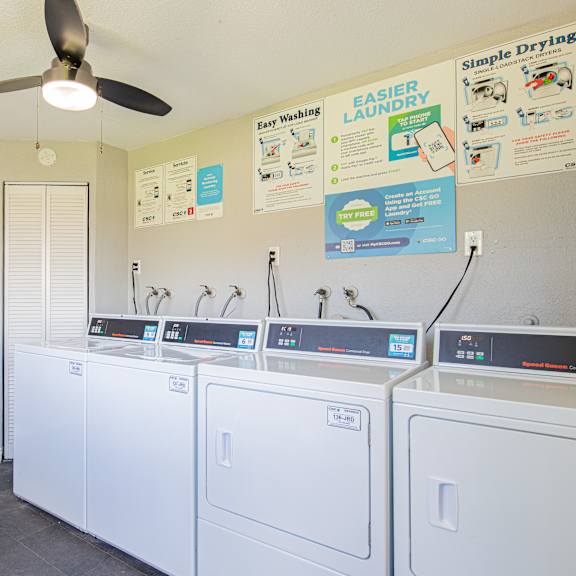 a laundry room with a fan and washing machines.