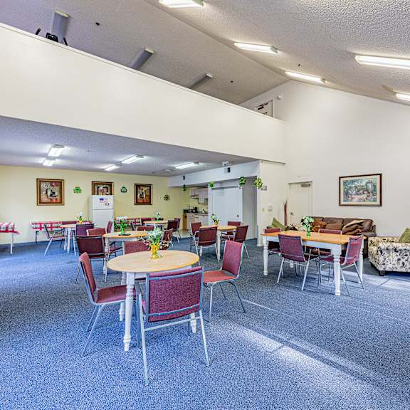 a room with tables and chairs and a piano.