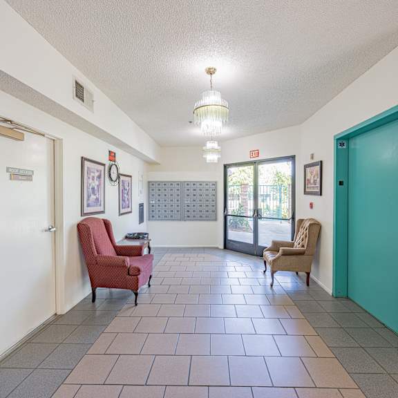 a hallway with a red chair and a brown chair.