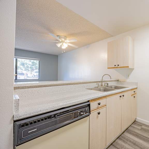 a kitchen with a white oven, sink, and cabinets.