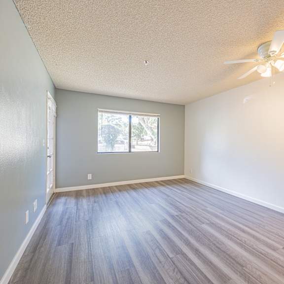 a room with a ceiling fan and a window.