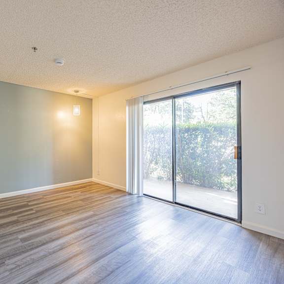 a room with wooden flooring and a sliding glass door.