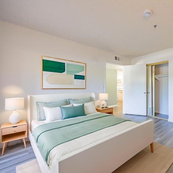 a bedroom with a bed, nightstand, and lamp.