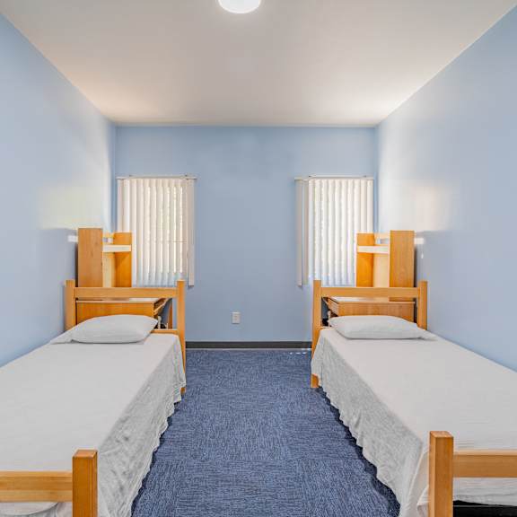 two beds in a room with blue walls.