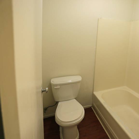 a white toilet and bathtub in a small bathroom.