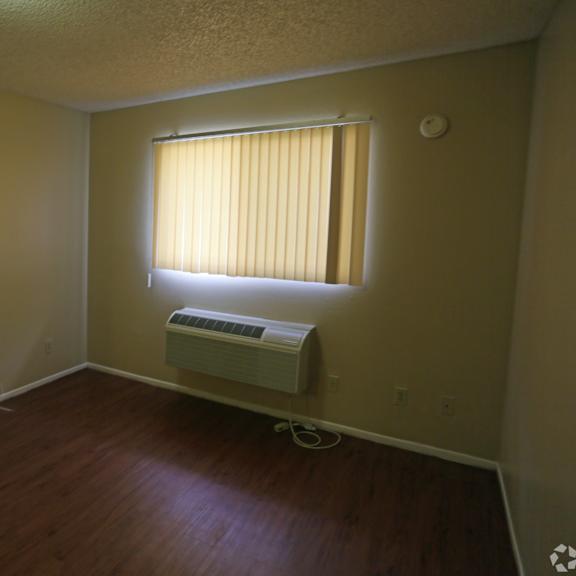 a room with a window and a wall-mounted air conditioner.