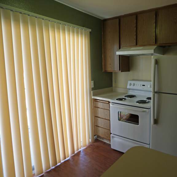 a kitchen with a white refrigerator, stove, and oven.