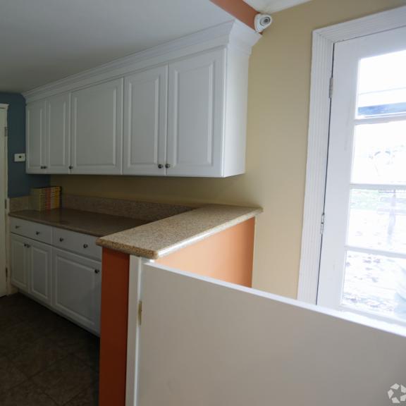 a kitchen with white cabinets and a stainless steel refrigerator.