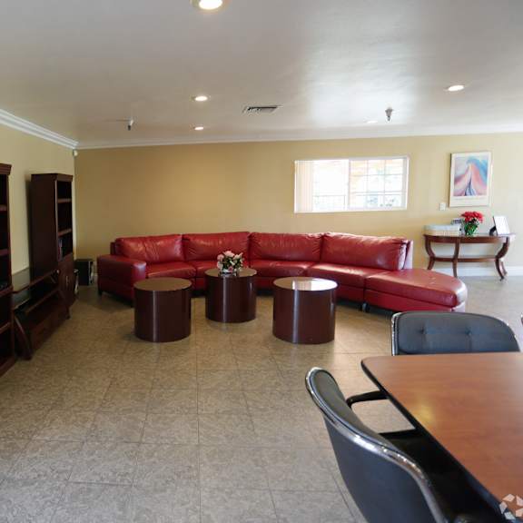 living room with red couch and brown chairs.