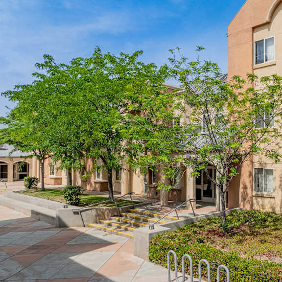 a building with trees and a sidewalk in front of it at international village ucr student housing, riverside, 92507