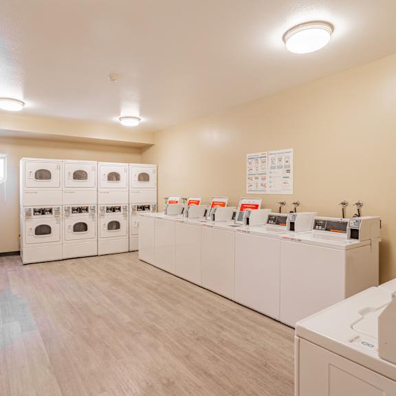 a laundry room with washers and dryers and a counter with sinks and laundry at international village ucr student housing, riverside, ca 92507