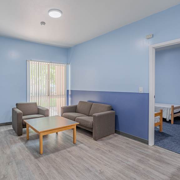 a living room with couches and a coffee table and a tv at international village ucr student housing, riverside