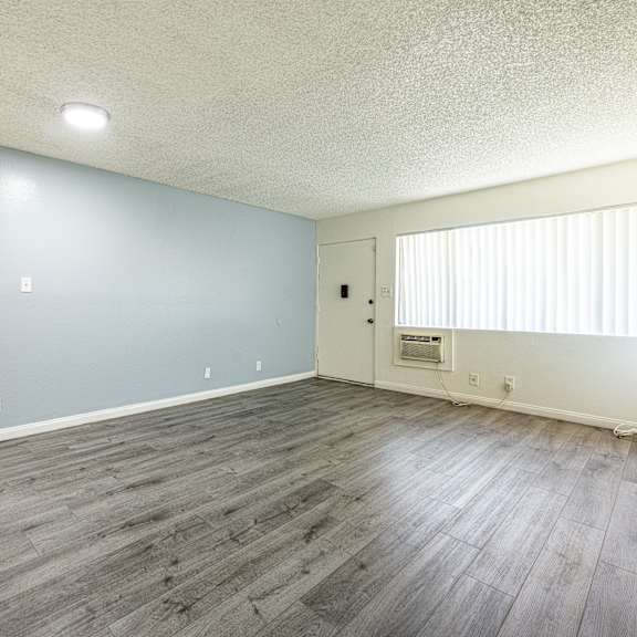a room with a light blue wall and wooden flooring.